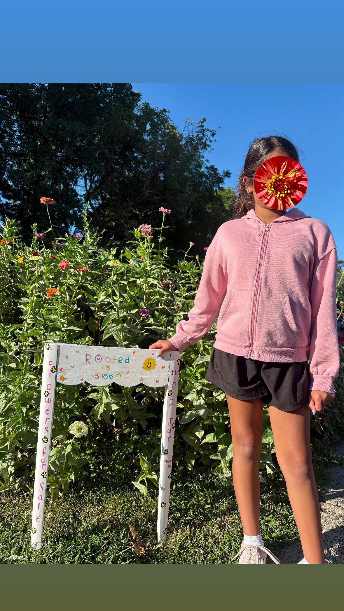 Child standing by a handmade Rooted to Bloom flower stand