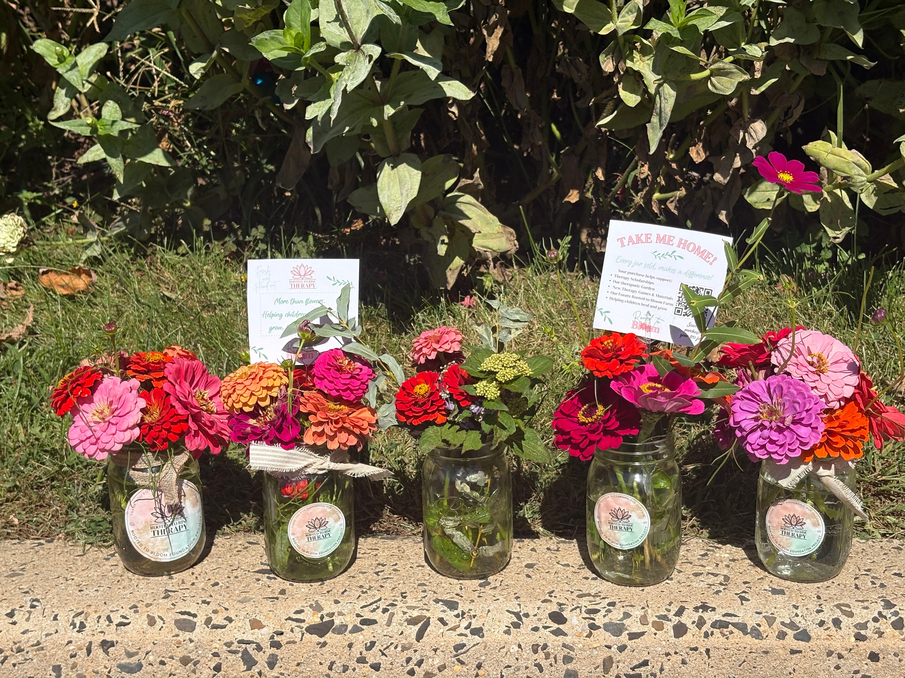 Colorful zinnia bouquets in branded mason jars with Take Me Home signs
